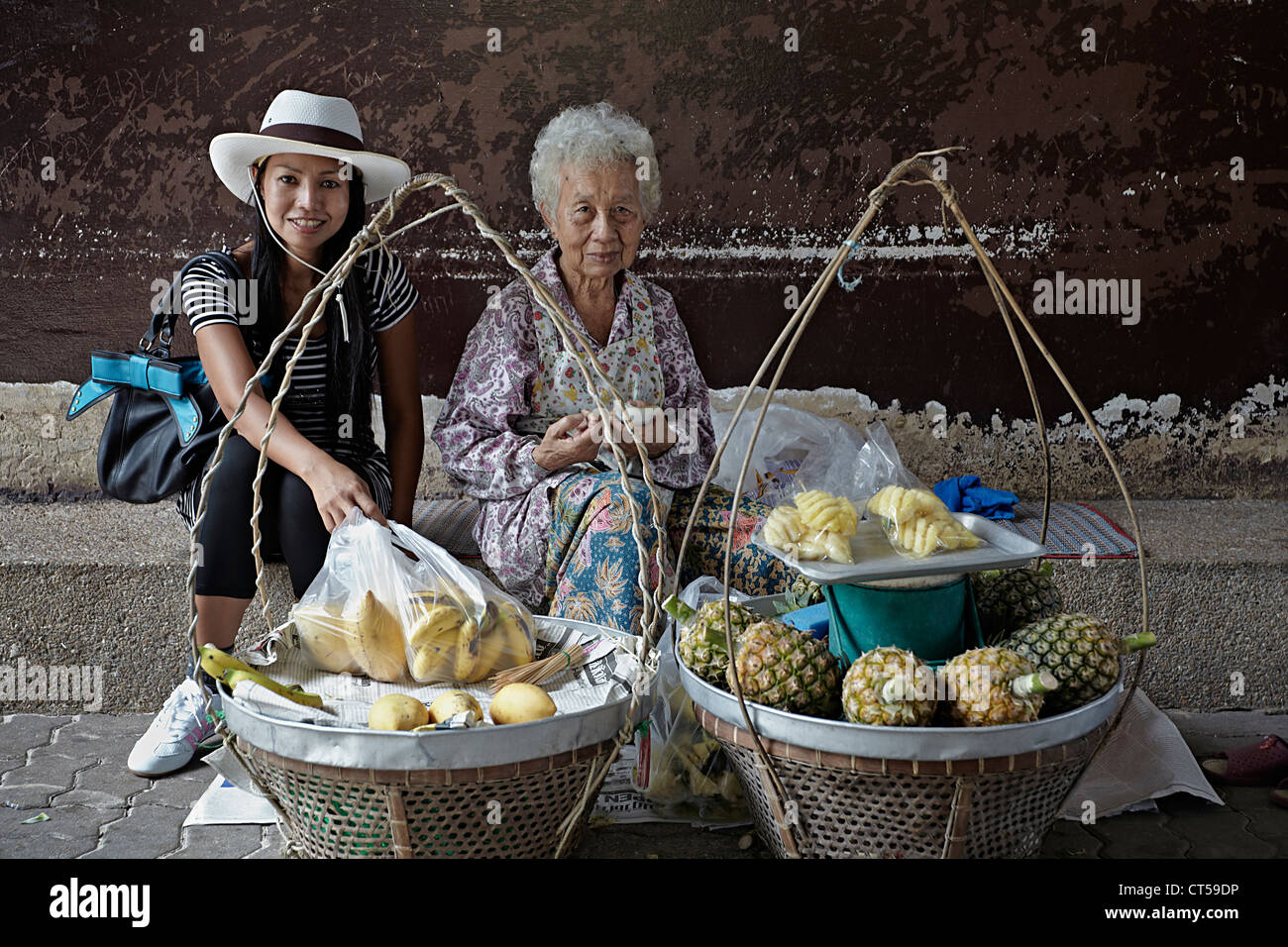Fornitore di cibo di strada in Thailandia. Donna moderna di giorno con vecchio fornitore tradizionale di cibo di strada femminile della Tailandia. Thailandia S.E. Asia Foto Stock