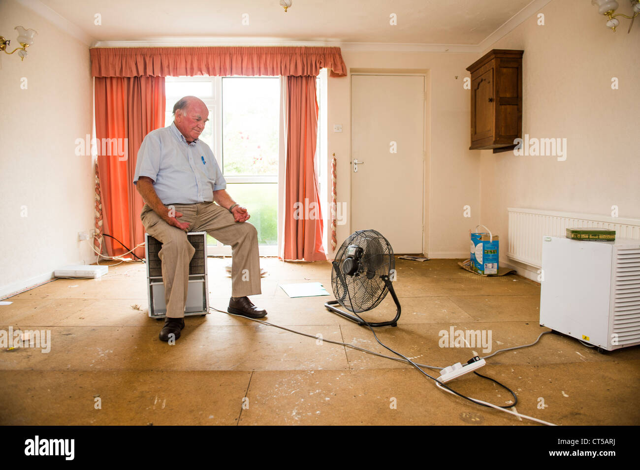 Un uomo la rilevazione delle rovine del living room lounge della sua casa vicino a Aberystwyth, a seguito delle inondazioni del mese di giugno 2012 Foto Stock