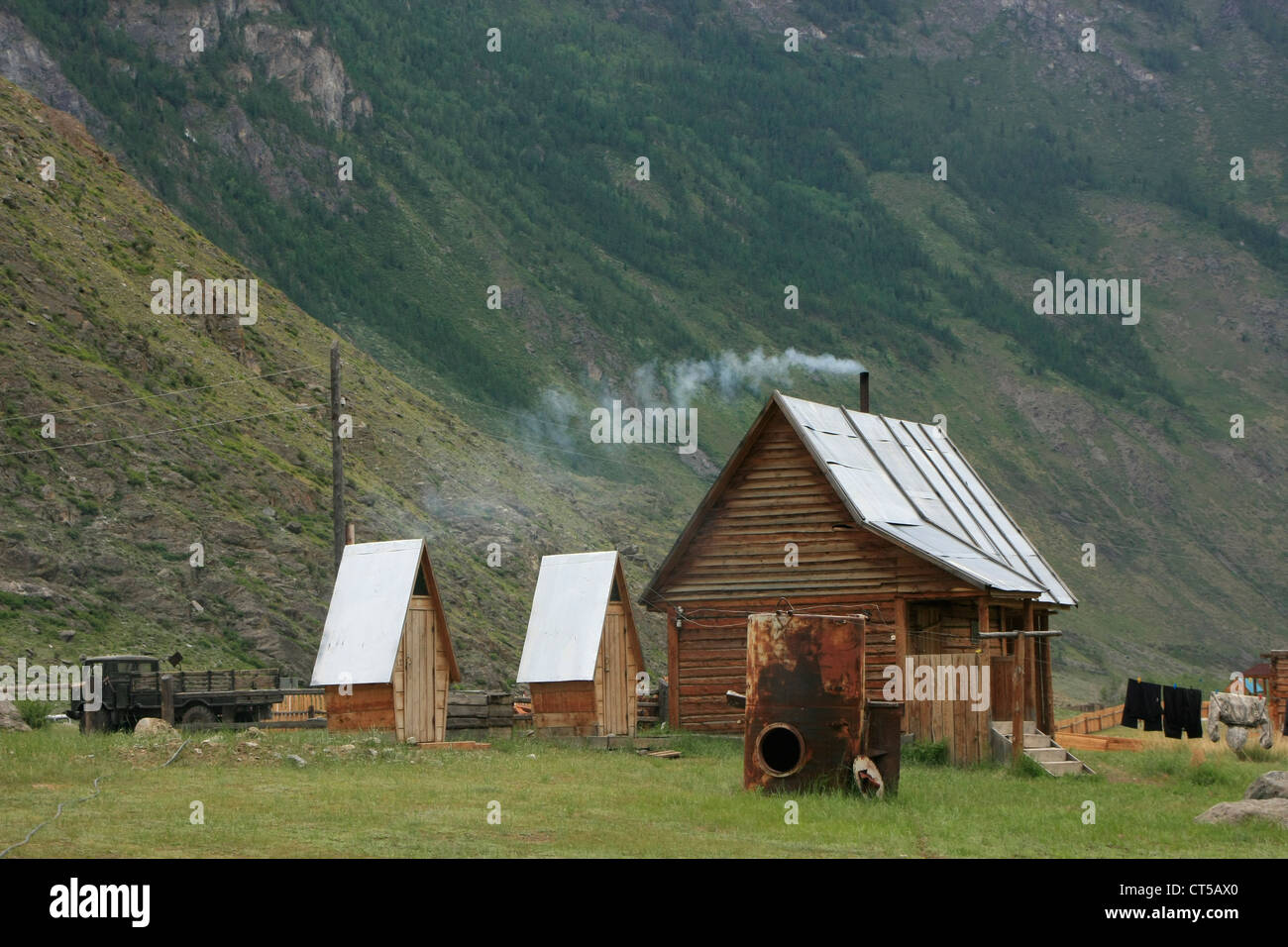 Piccola cabina in un canyon con fumo proveniente dal camino, Fiume Chulyshman Valley, Altai, Siberia, Russia Foto Stock