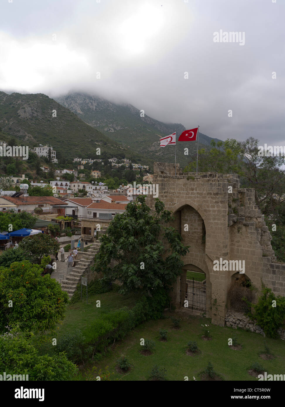 dh Abbazia di Bellapais KYRENIA CIPRO SETTENTRIONALE Bellapais Abbazia rovine bandiere turche e Besparmak catena montuosa nord Foto Stock