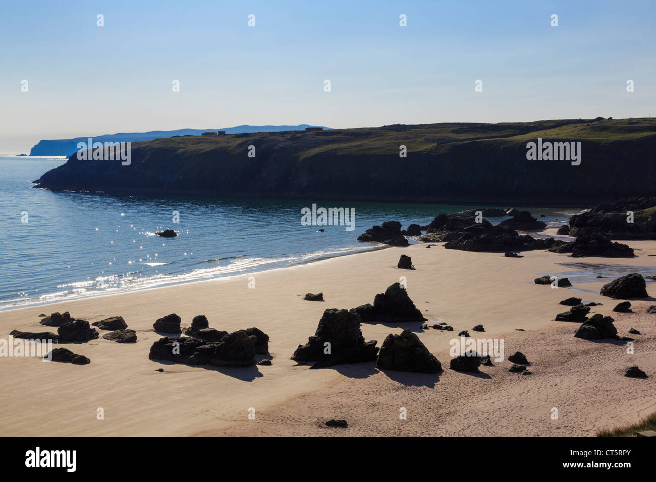 Stagliano rocce su vuoto spiaggia sabbiosa con un mare scintillante in prima mattinata a Sango Bay Durness Sutherland Highland Scozia UK Foto Stock