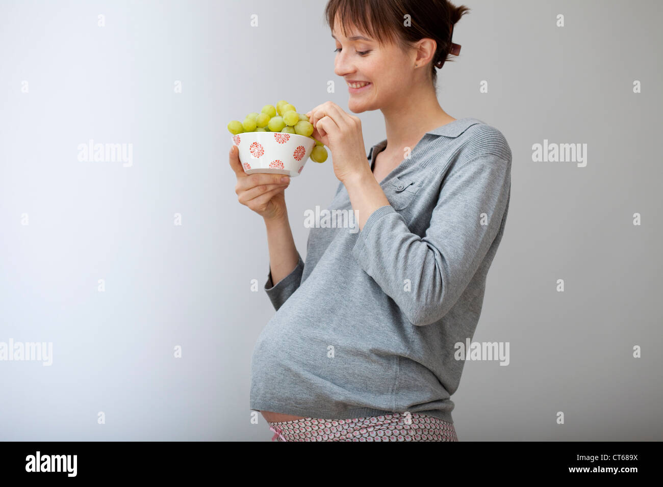 Donna incinta di mangiare Foto Stock