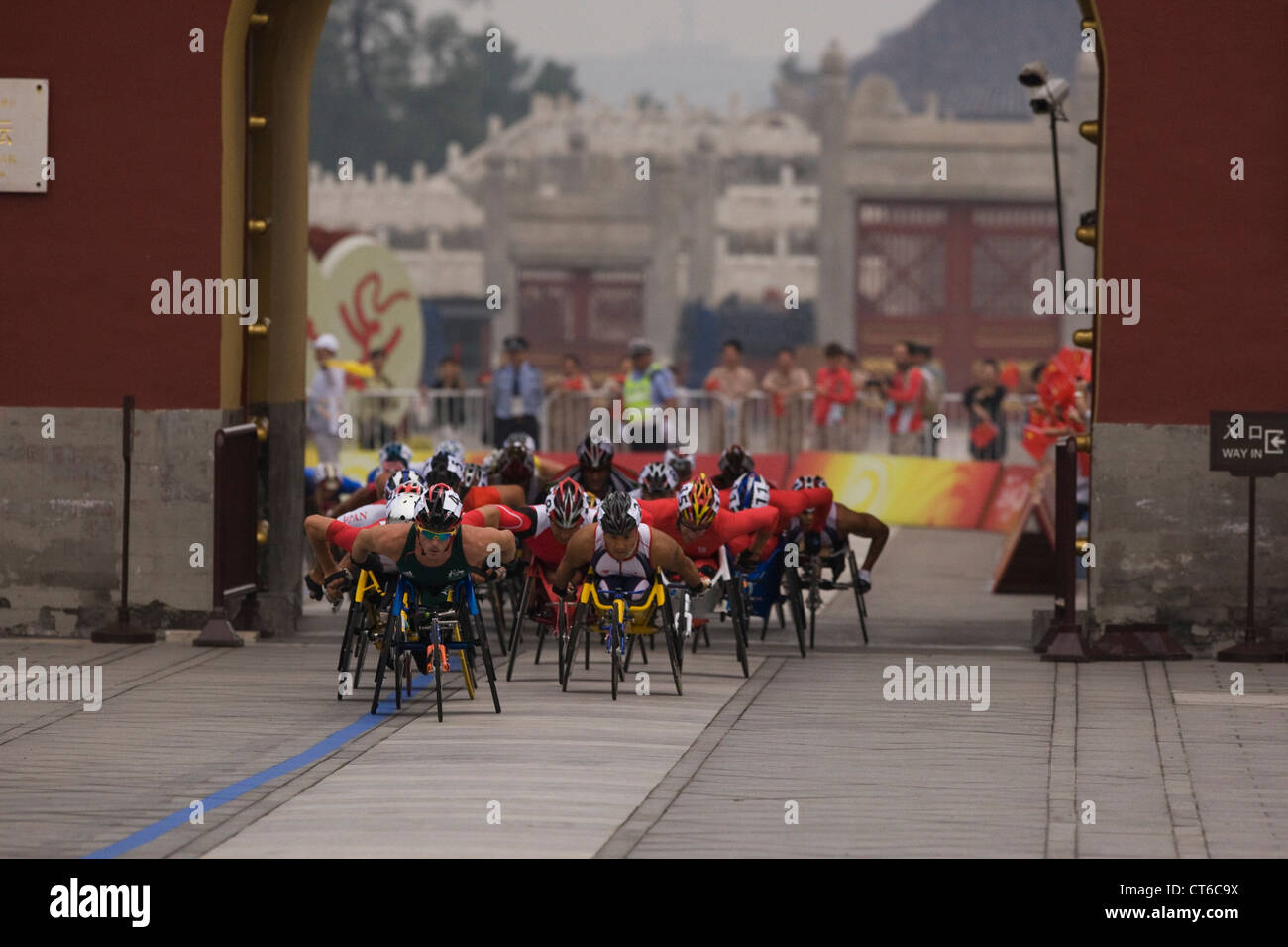 Sedia a rotelle i corridori della maratona passano attraverso una Pechino city gate durante il 2008 Paralimpici di maratona in settembre, 2008. Foto Stock