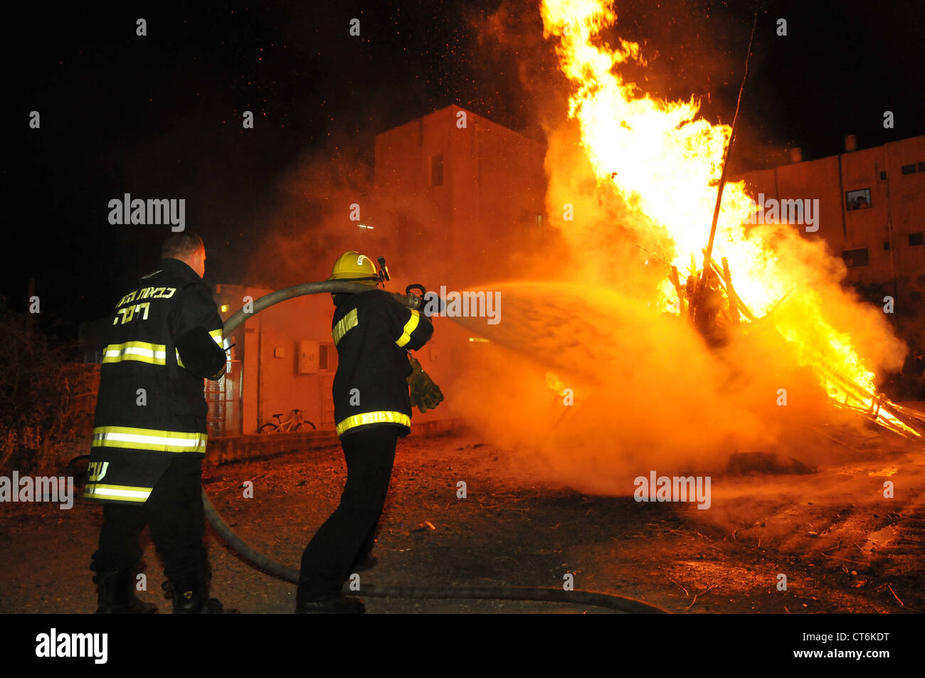 Israele Haifa, pompiere spegnere un grande falò durante il lag b'omer celebrazioni Foto Stock