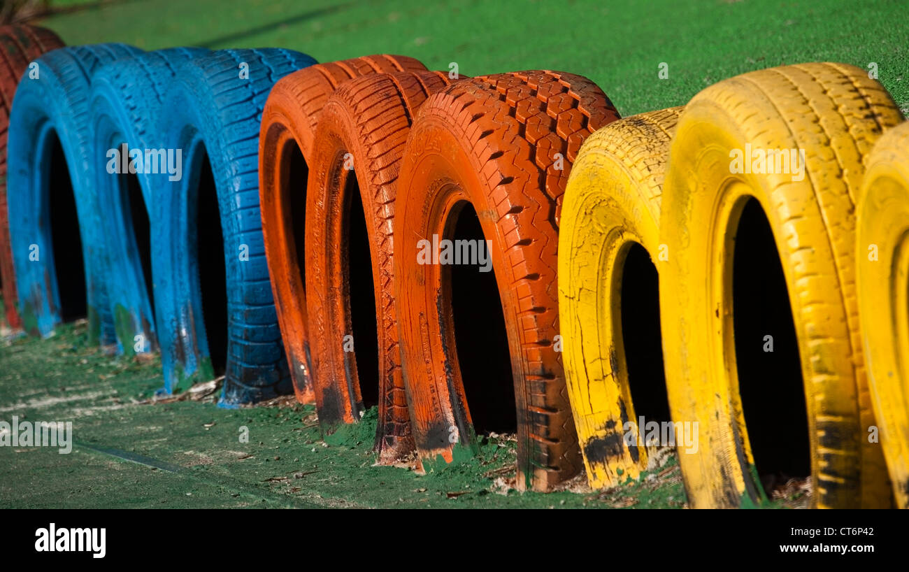 Gruppo di dipinti multicolore di pneumatici in parco giochi Foto Stock