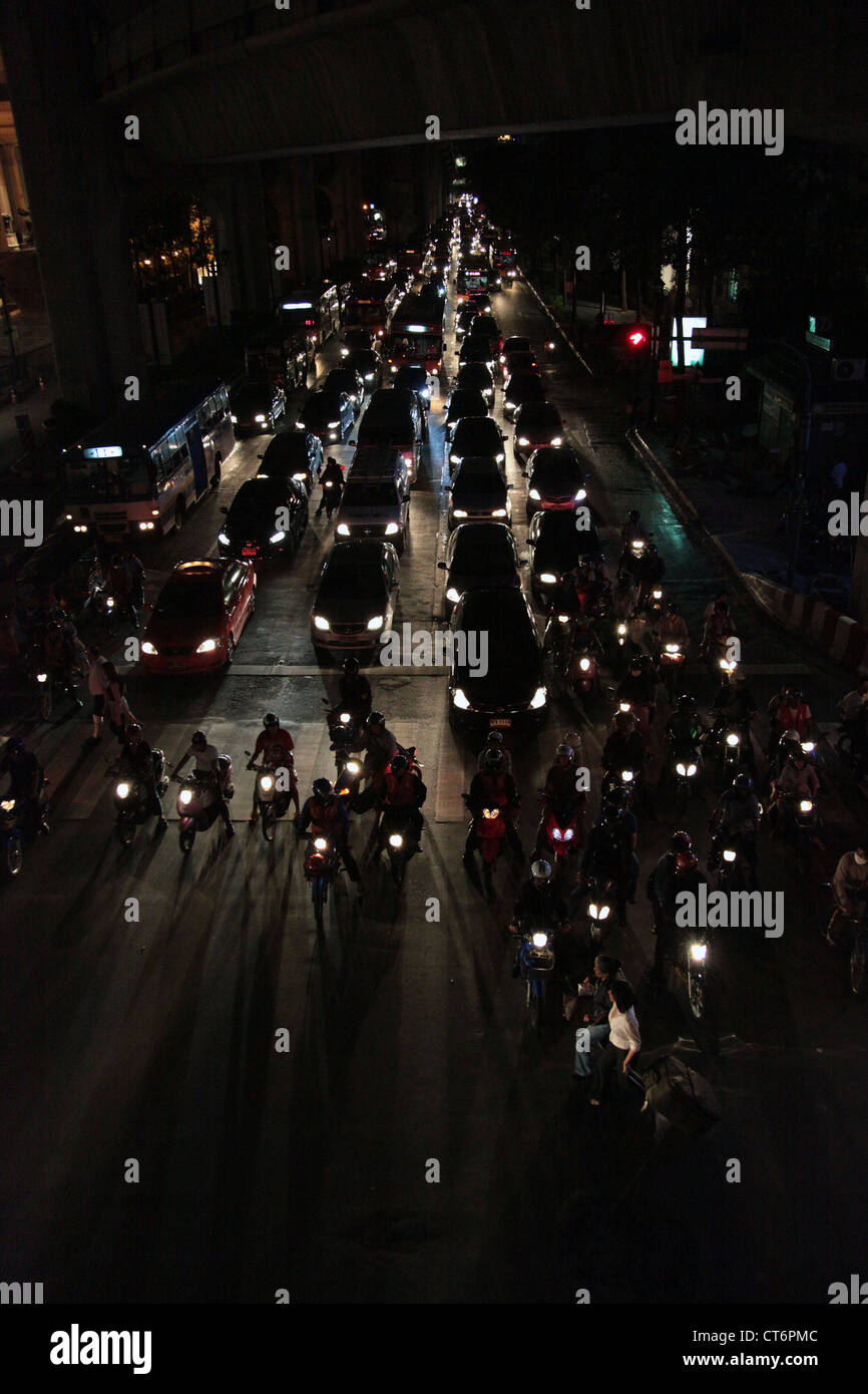Si tratta di una foto del traffico bu notte nella città di Bangkok in Thailandia. Siamo in grado di vedere le automobili, gli autobus biciclette in attesa al semaforo Foto Stock