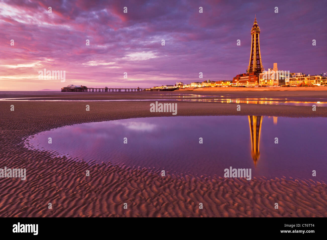 La torre di Blackpool si riflette in una piscina di marea e divertimenti fronte mare illuminati al tramonto Lancashire Inghilterra GB UK Europe Foto Stock