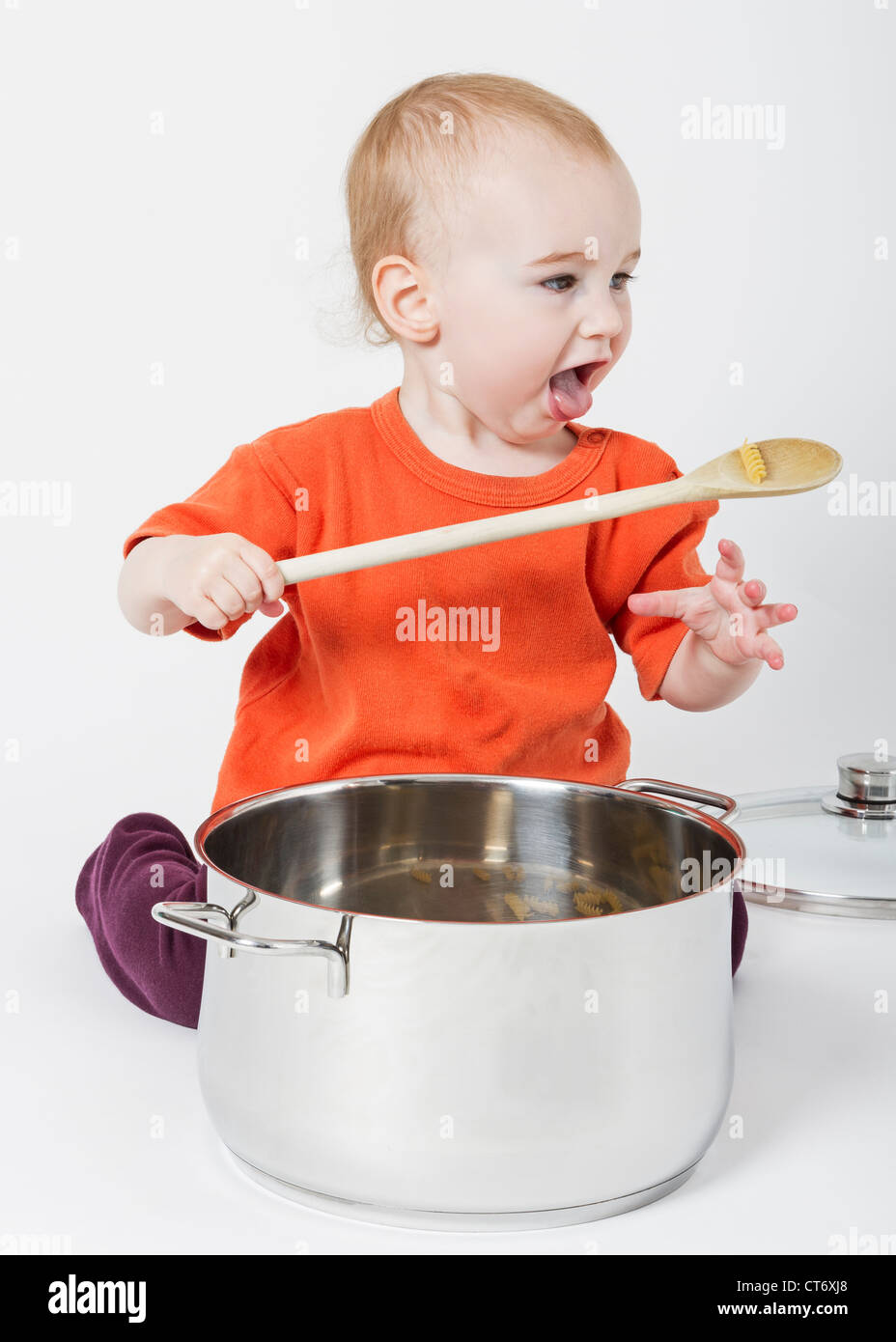 Bambino con grande pentola di cottura isolata su sfondo neutro Foto Stock