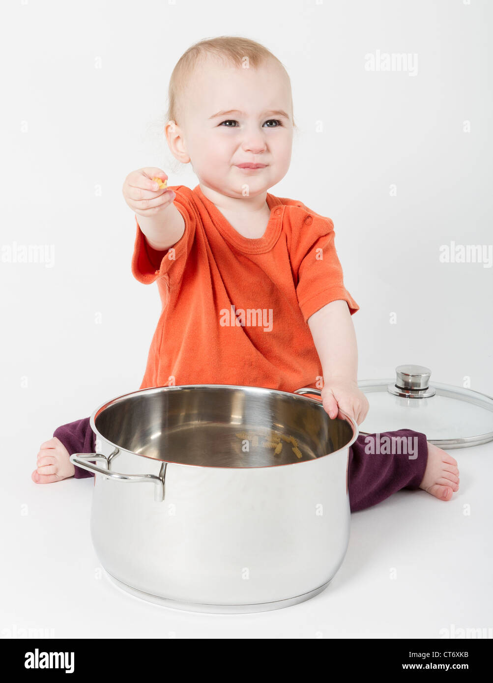 Bambino con grande pentola di cottura su sfondo neutro Foto Stock
