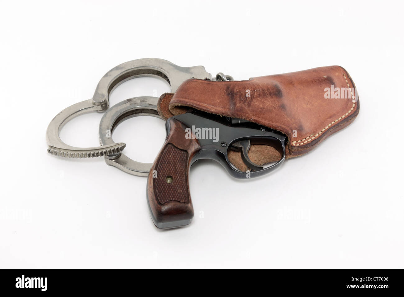 Vintage revolver in custodia in pelle con manette su sfondo bianco Foto Stock