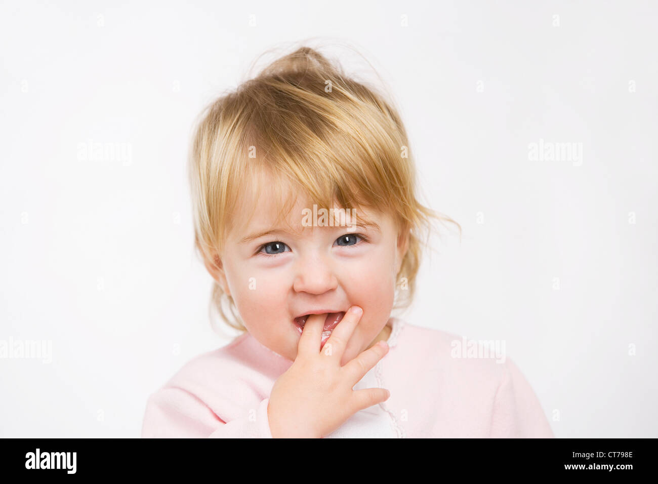 Ritratto di bambina mettendo il dito in bocca Foto Stock