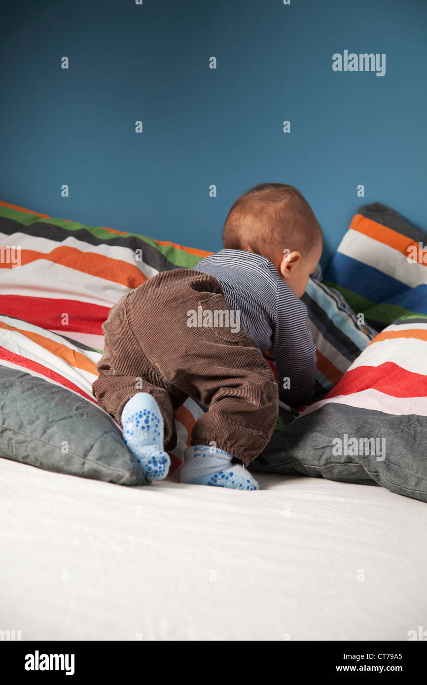 Baby strisciando attraverso il letto Foto Stock