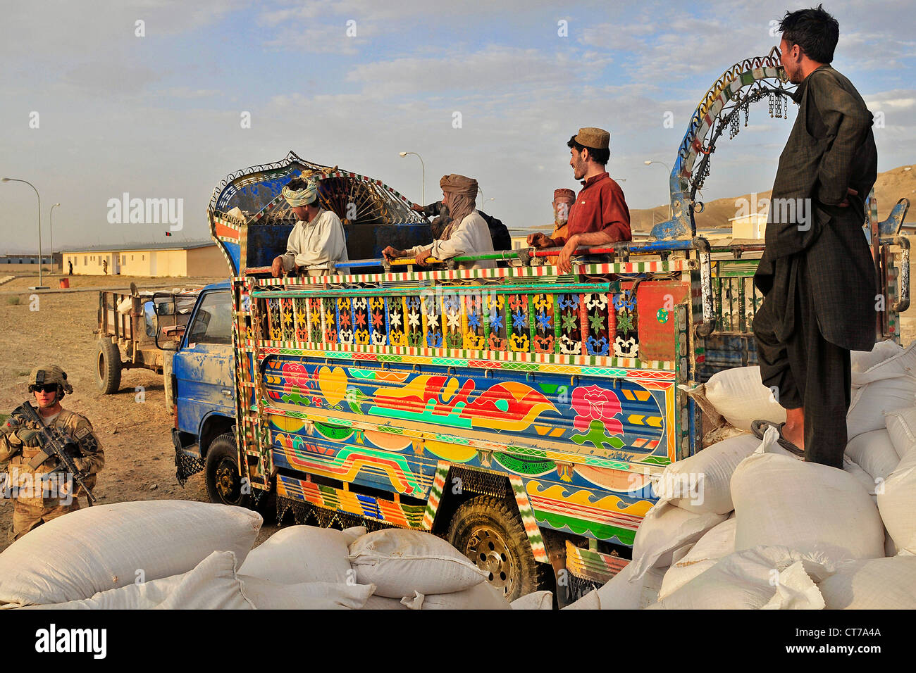 Afghan camionisti di pausa dopo lo scarico di sacchi di grano da un jingle carrello durante il funzionamento Buffalo Thunder II presso il centro distretto Giugno 30, 2012 in Shorabak, Afghanistan. Foto Stock