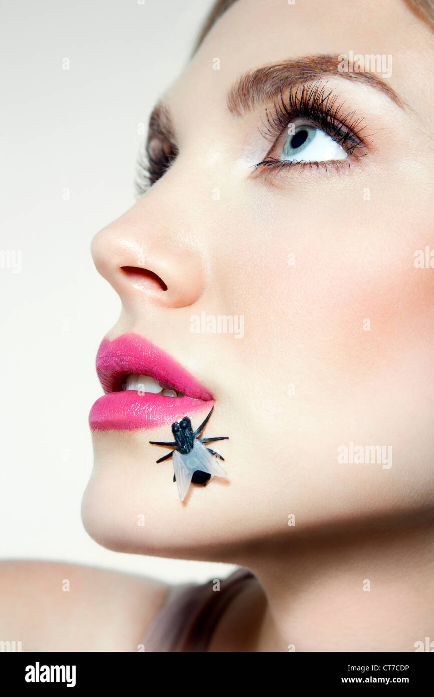 Giovane donna con plastica volare sulla faccia Foto Stock