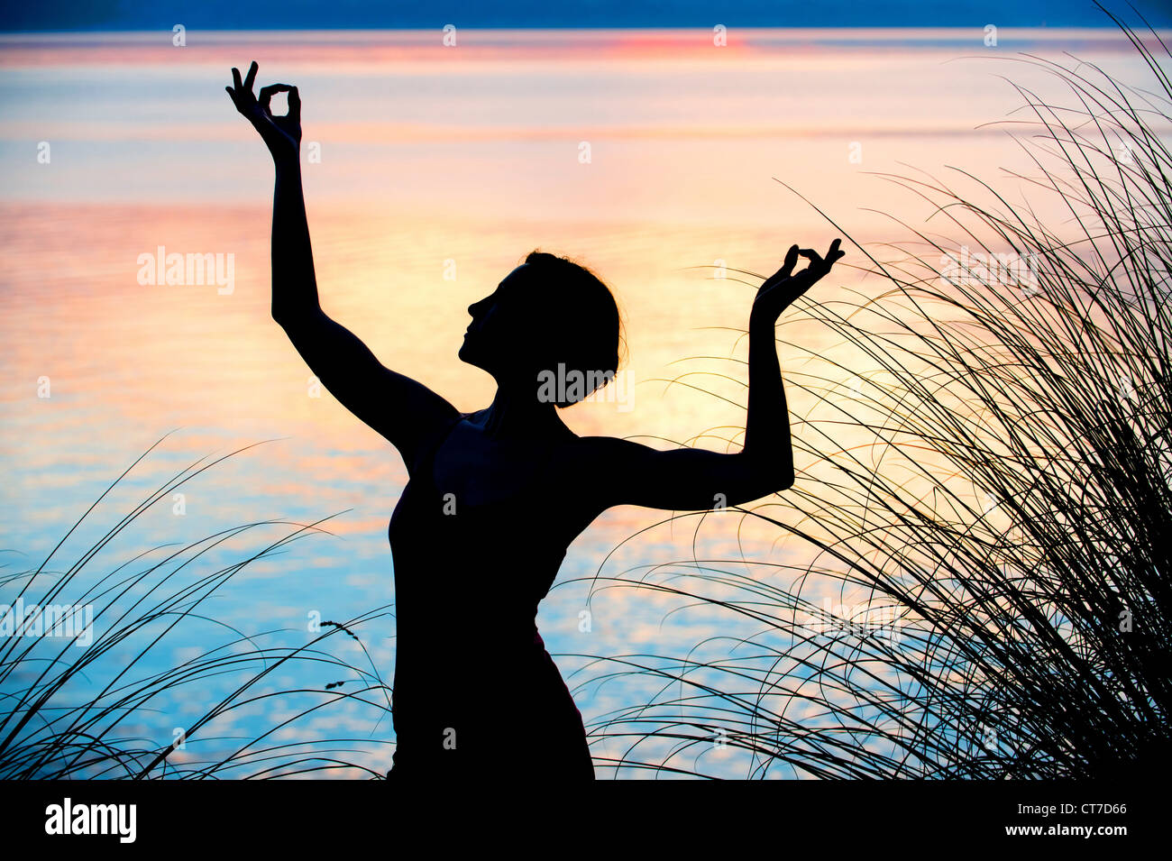 Donna di eseguire la danza al tramonto Foto Stock