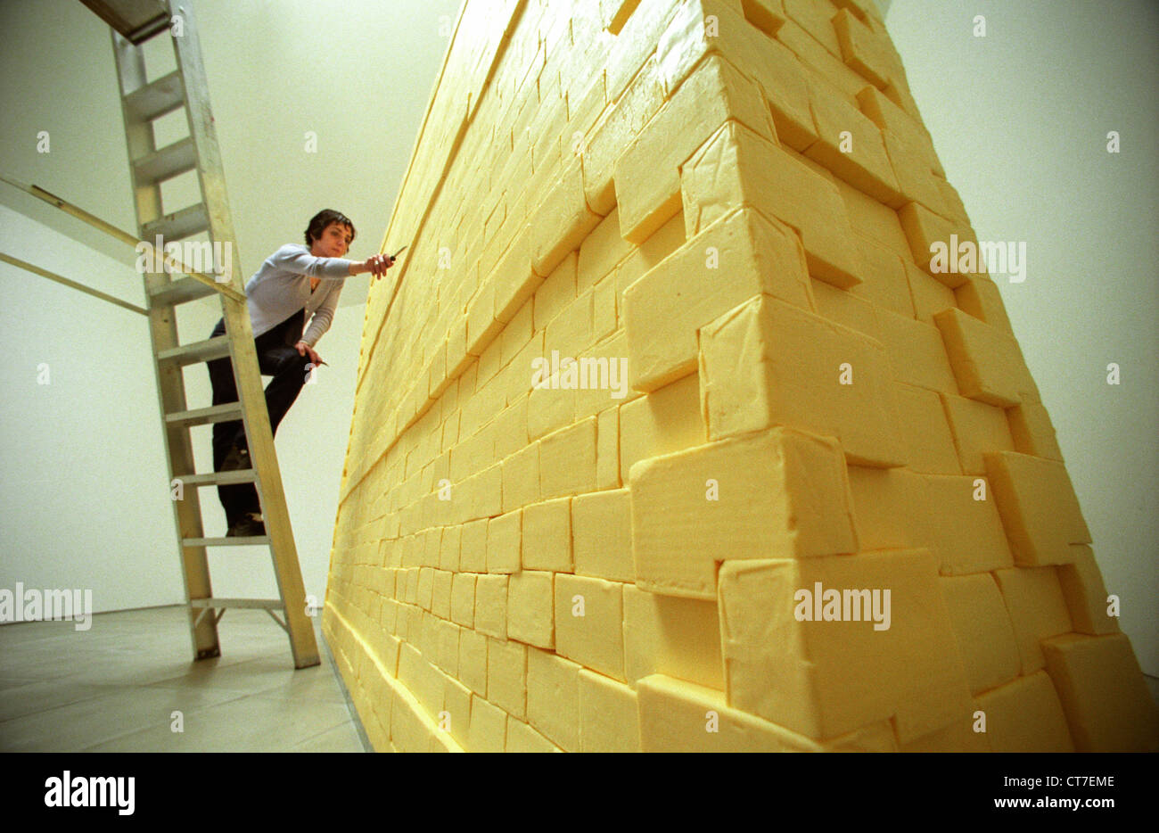 Donna artista sulla scaletta, scolpire una parete realizzata interamente di burro. Ha pesato di tre quarti di una tonnellata ed è stato finanziato con il denaro della lotteria. Foto Stock