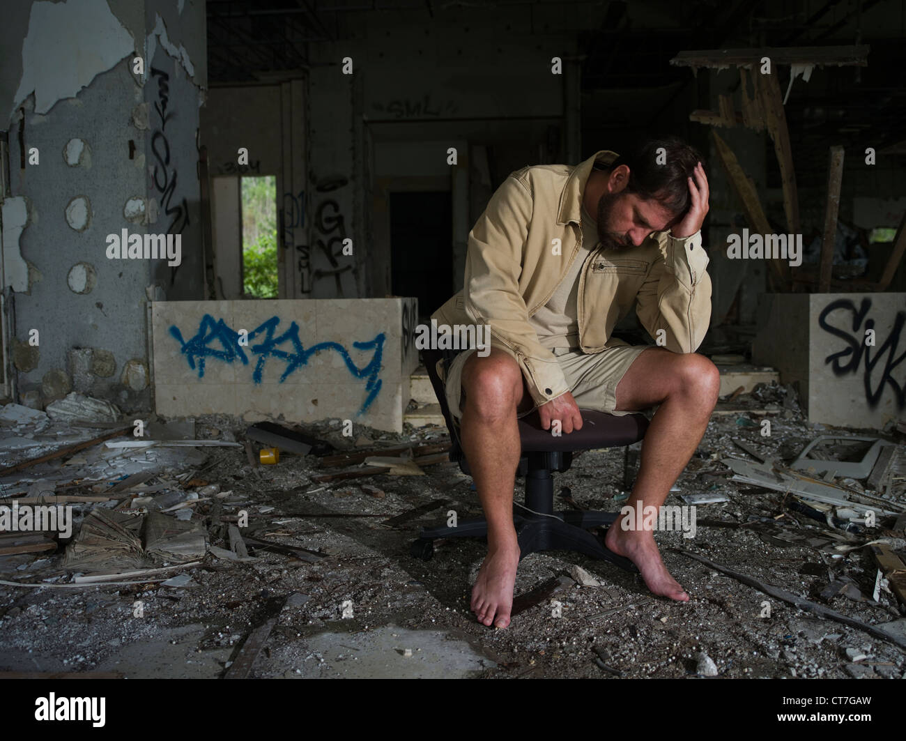 Uomo seduto in edificio abbandonato Foto Stock