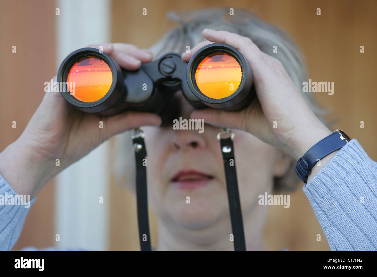 Una donna guarda attraverso il binocolo Foto Stock