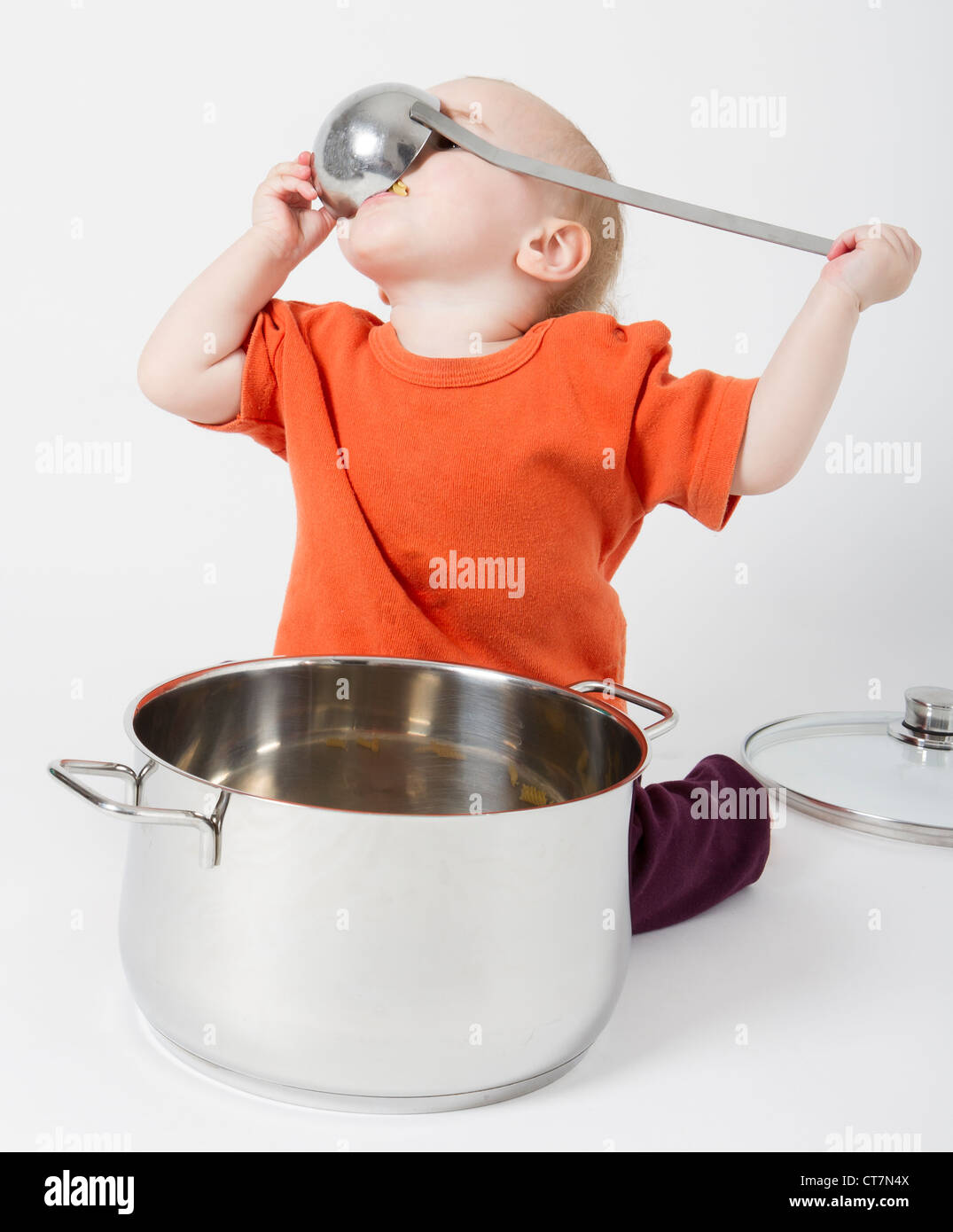 Bambino con grande pentola di cottura su sfondo grigio Foto Stock