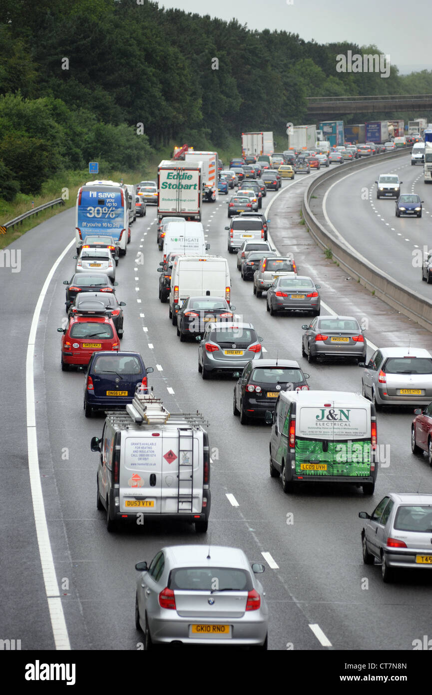 Il traffico pesante sulla autostrada M6 vicino a Stafford RI Code inceppamenti bikers di trasporto auto CODE MOTORING alberi barriera rumore REGNO UNITO Foto Stock