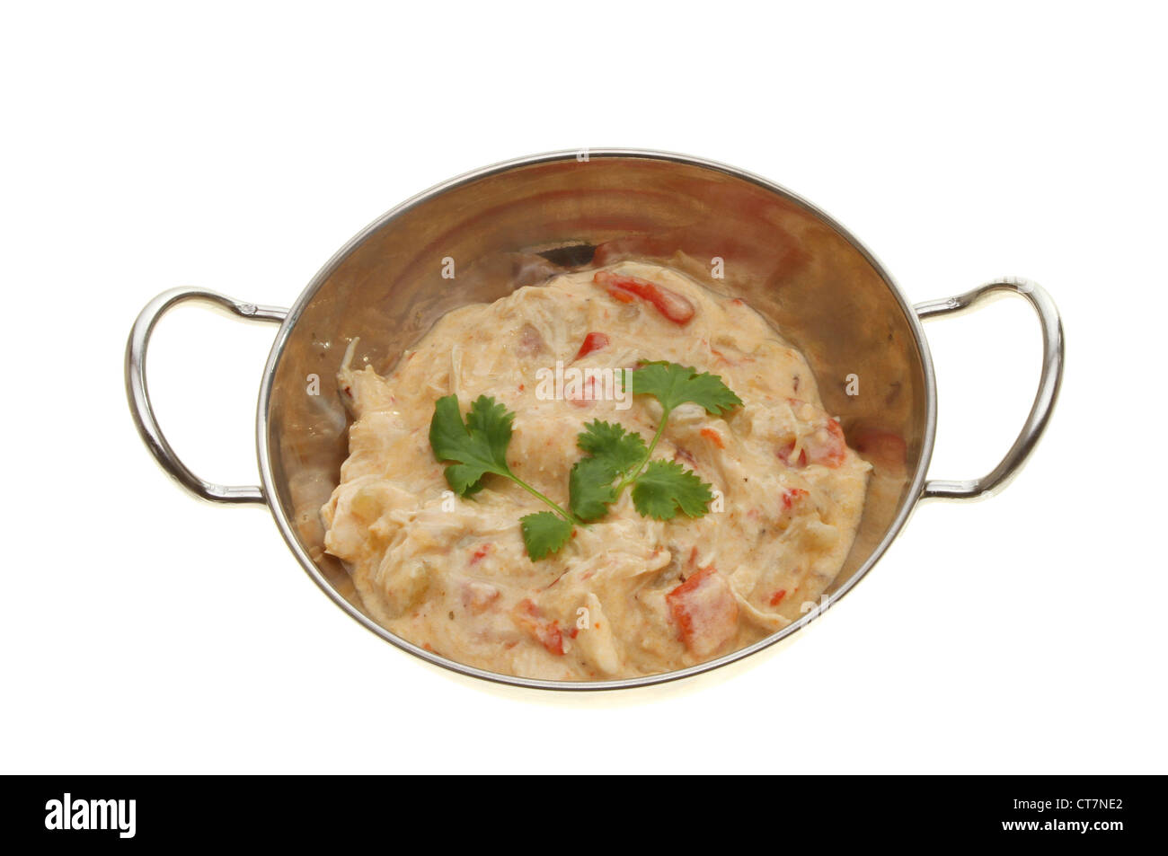 Pollo al curry con coriandolo guarnire in un piatto di Balti isolata contro bianco Foto Stock