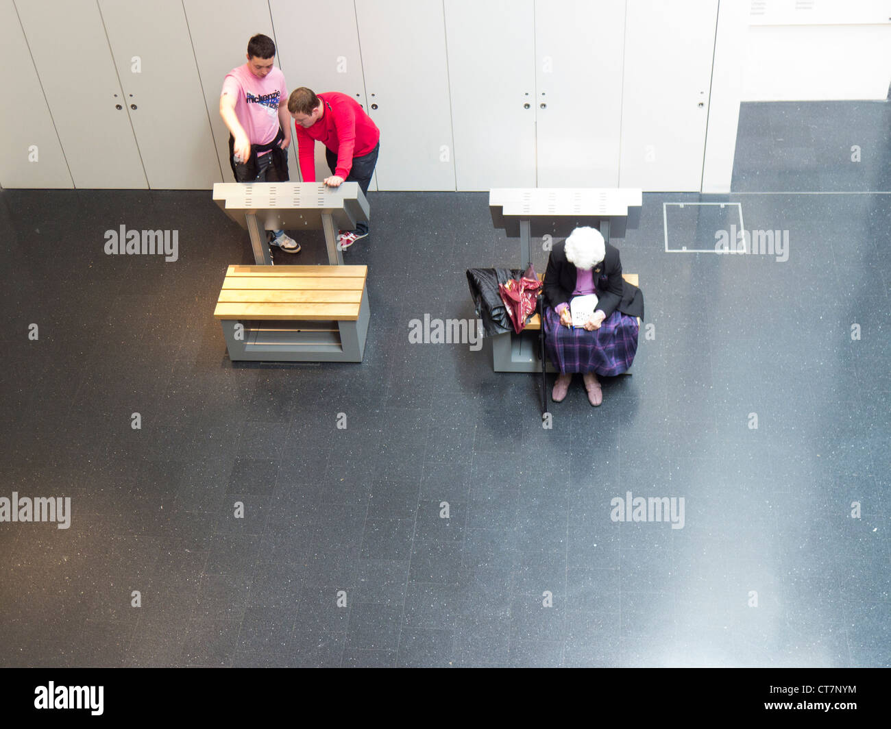 Due giovani uomini e una donna anziana in una apertura interna Museum gallery spazio. Foto Stock Due giovani uomini e una donna anziana in una apertura interna Museum gallery spazio. Foto Stock