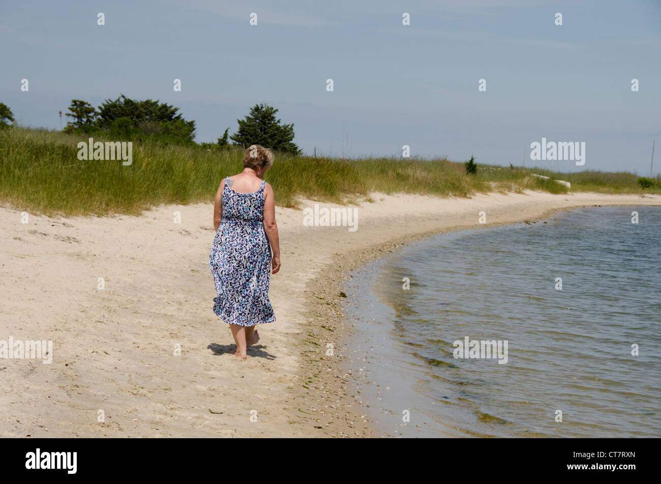 Massachusetts, Martha's Vineyard, Vineyard Haven. donna camminando sulla spiaggia. Modello rilasciato. Foto Stock