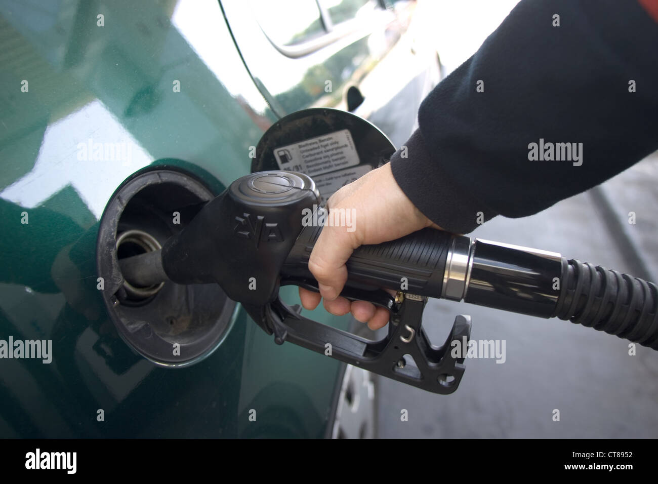 Foto di simbolo e le mani di un automobilista quando si effettua il rifornimento di carburante Foto Stock