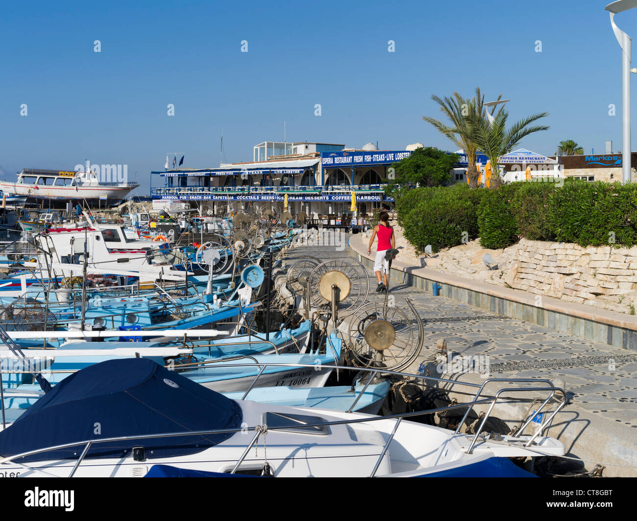 dh Harbour Promenade AYIA NAPA SOUTH CIPRO Girl a piedi lungo barche caffè ristorante lungomare gente del sud Foto Stock