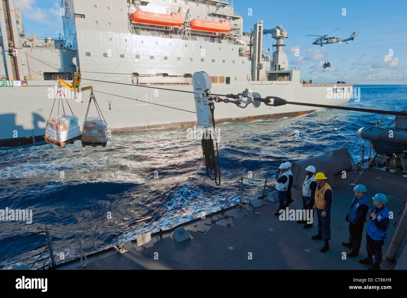 I marinai statunitensi assegnati al cacciatorpediniere missilistico guidato USS McCampbell (DDG 85) aspettano che le palette di carico arrivino dalla nave da carico e munizioni USNS Amelia Earheart (T-AKE 6) durante un rifornimento in mare nel Mare della Cina orientale 8 luglio 2012. McCampbell era in corso di svolgimento delle operazioni di sicurezza marittima e di cooperazione per la sicurezza del teatro nella 7th Fleet degli Stati Uniti. Foto Stock