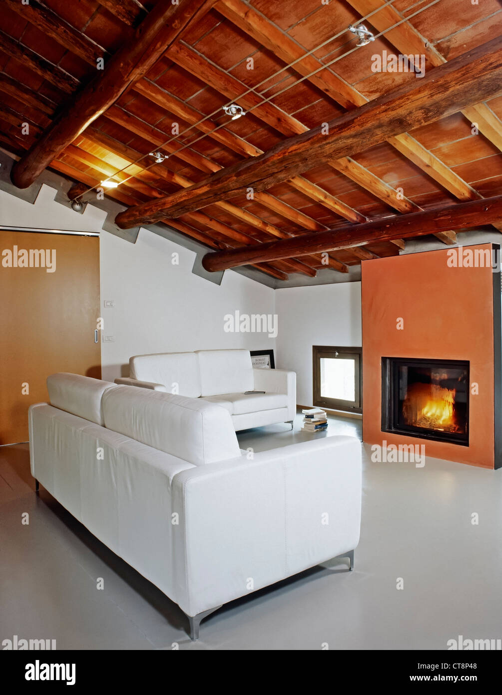 Moderno soggiorno con camino in mansarda e tetto in legno Foto stock - Alamy