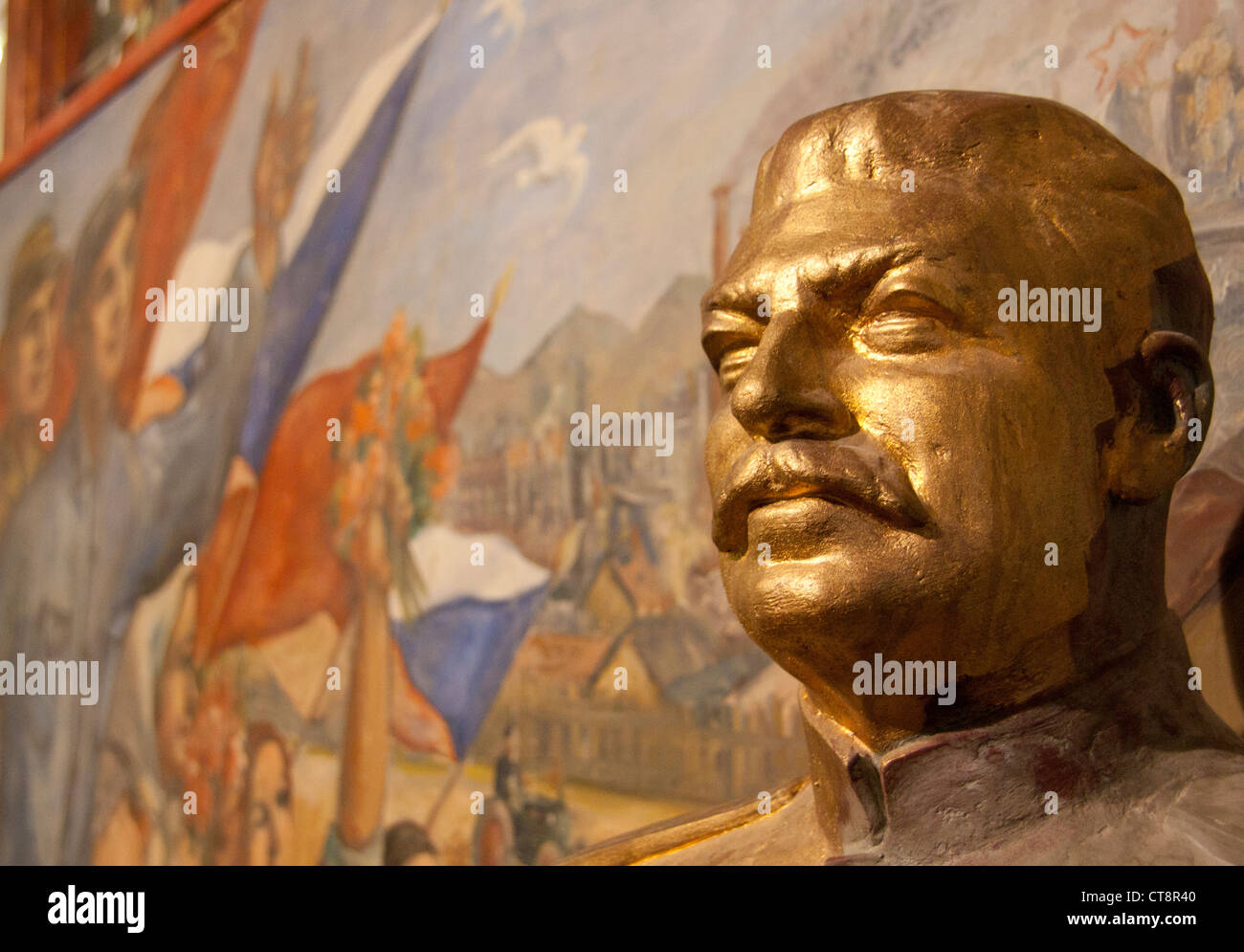 Oro busto di Josef Stalin con realismo socialista murale in stile Museo del Comunismo di Praga Repubblica Ceca Europa UE Foto Stock