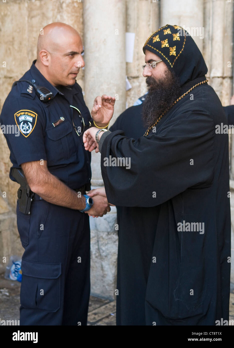 Sacerdote copto incontro con la polizia israeliana officer presso la chiesa del Santo Sepolcro di Gerusalemme Israele durante il Venerdì Santo Foto Stock