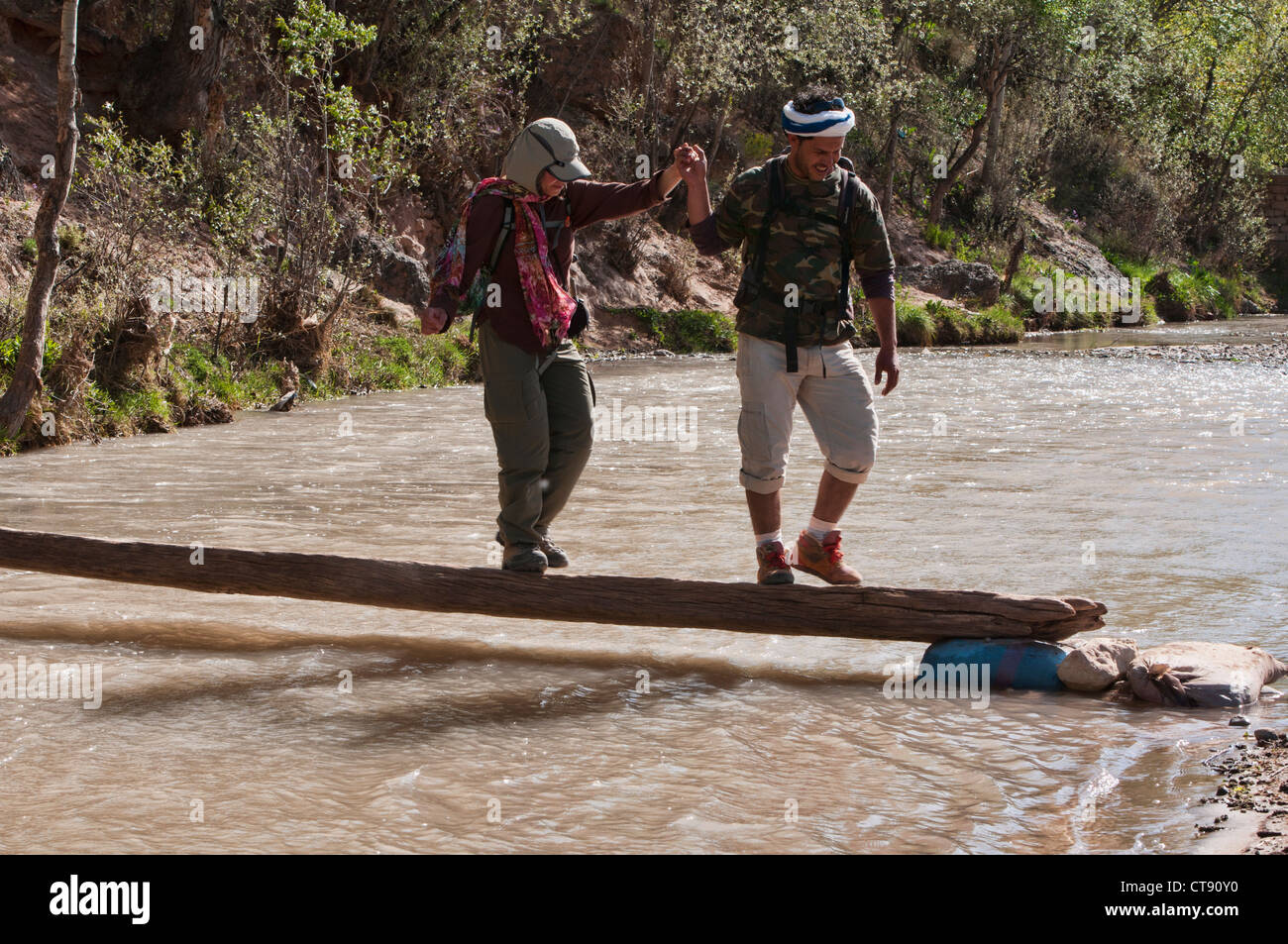 Attraversare un fiume durante il trekking del sud montagne Atlas, Marocco Foto Stock