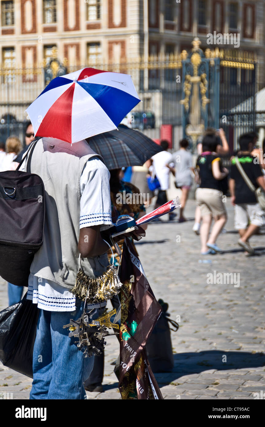Uomo che vendono souvenir da Parigi di fronte al Castello di Versailles cancello principale - Place d'Armes, Versailles, Parigi - Francia Foto Stock