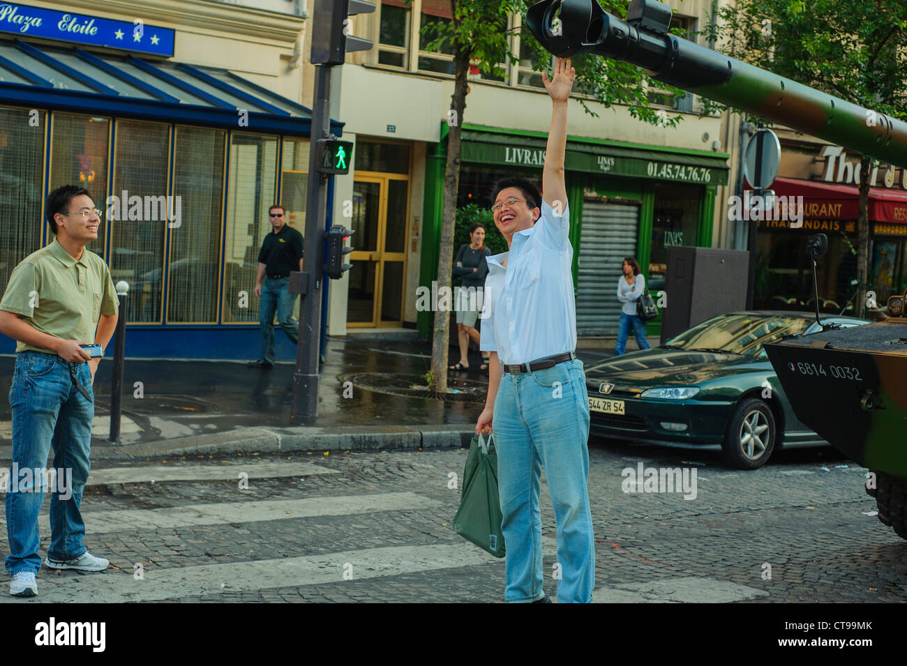 Parigi, Francia, eventi pubblici, Bastille Day celebrazione xiv di luglio parata militare, sul Champs-Elysees. I turisti cinesi, uomo di toccare il serbatoio prima di parata. Foto Stock