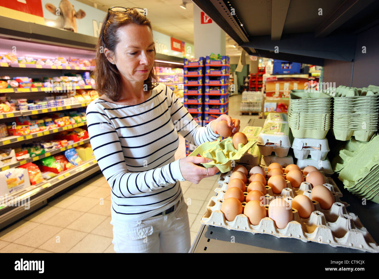 La donna è lo shopping in un grande supermercato. Fattoria fresco uova. Foto Stock