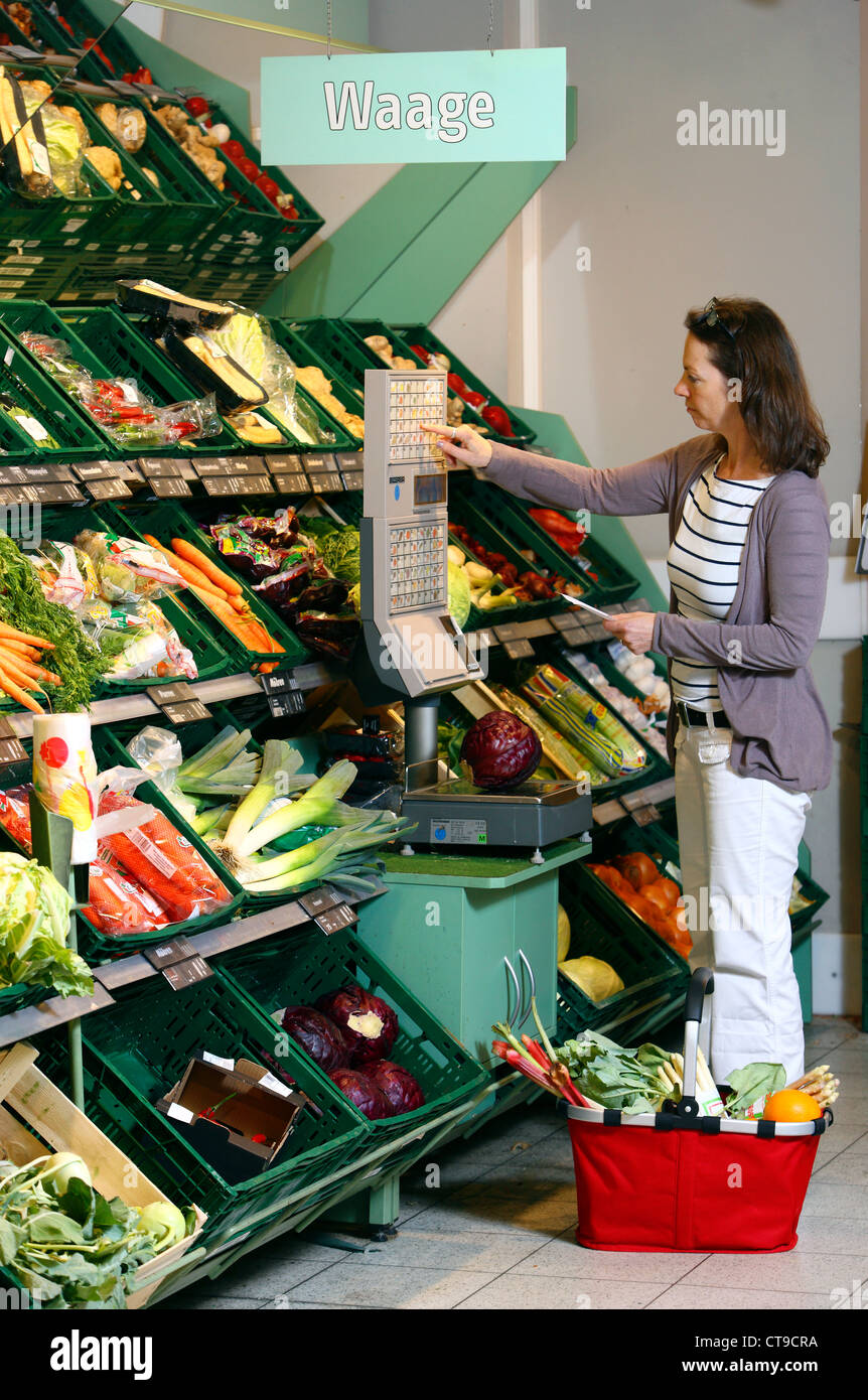 La donna è lo shopping in un grande supermercato. La frutta e la verdura al reparto. Foto Stock