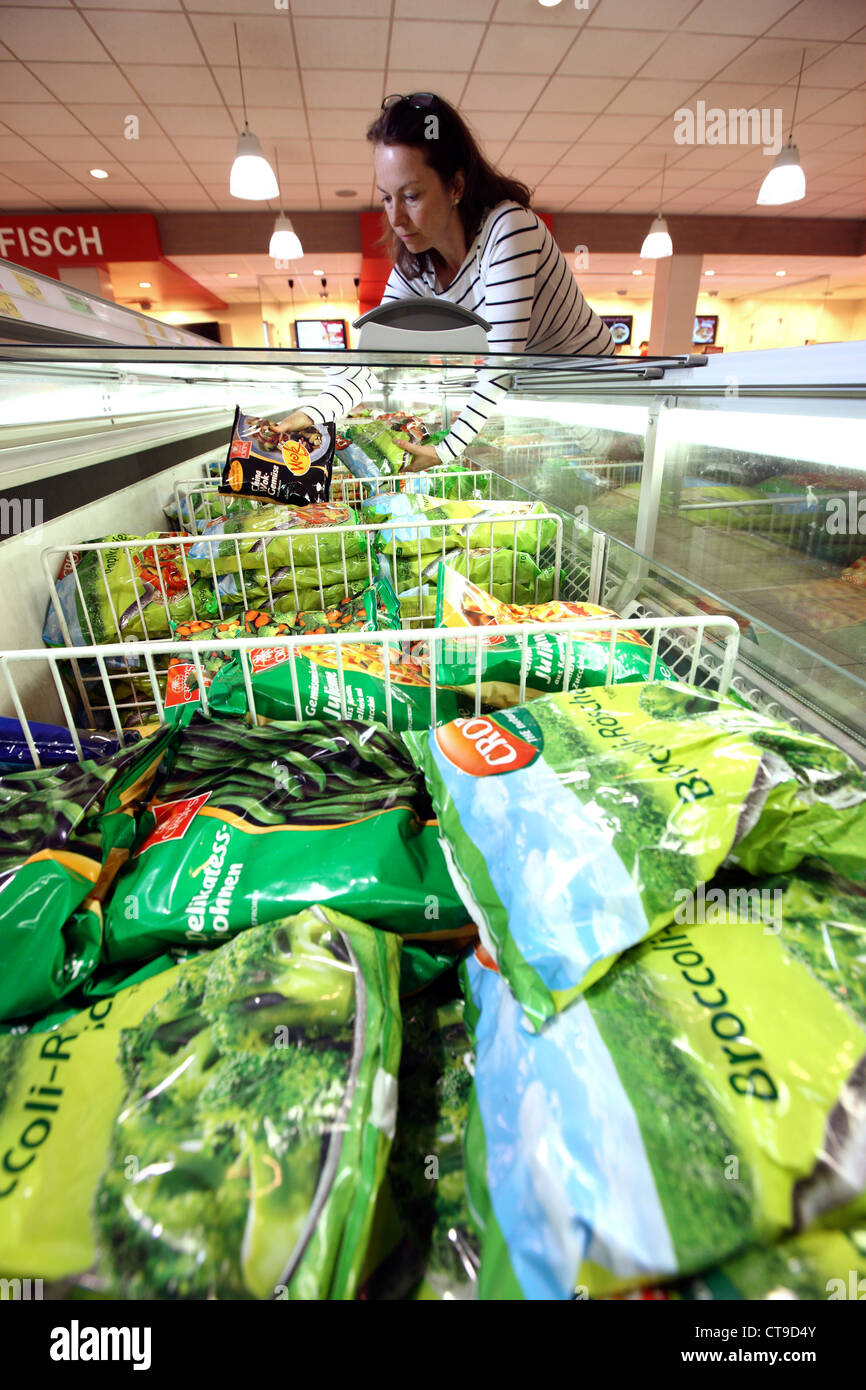 La donna è lo shopping in un grande supermercato. Congelatore, congelati prodotti alimentari. Foto Stock
