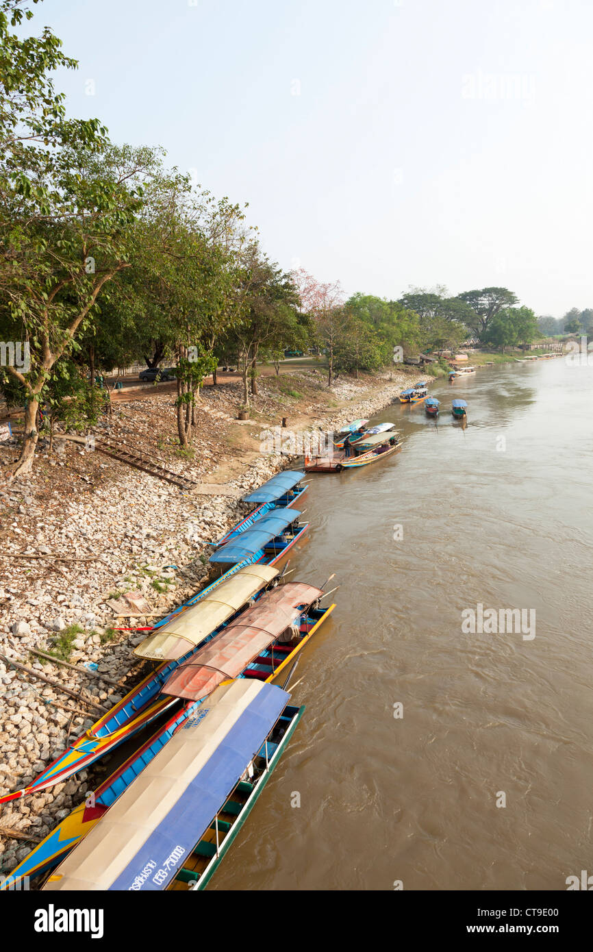 Lunga coda di barche ormeggiate su una banca del fiume Kok, a Chiang Rai (Thailandia). Bateaux à longue queue sur la rivière Kok. Foto Stock