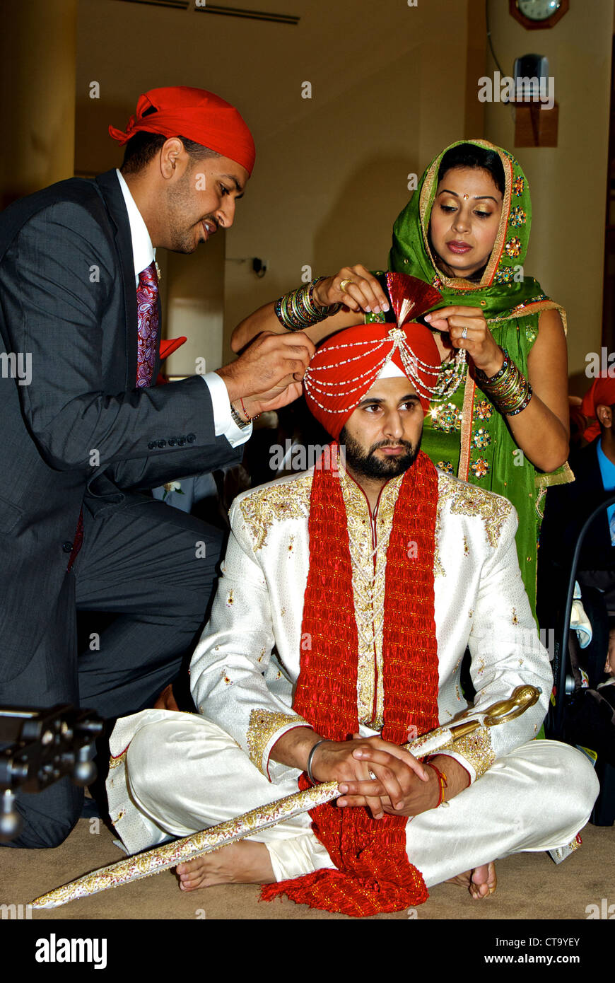 Tradizionale East Indian wedding groom familiari rimuovere speciale pre-cerimonia bordato abito di testa decorazioni rimosso Foto Stock