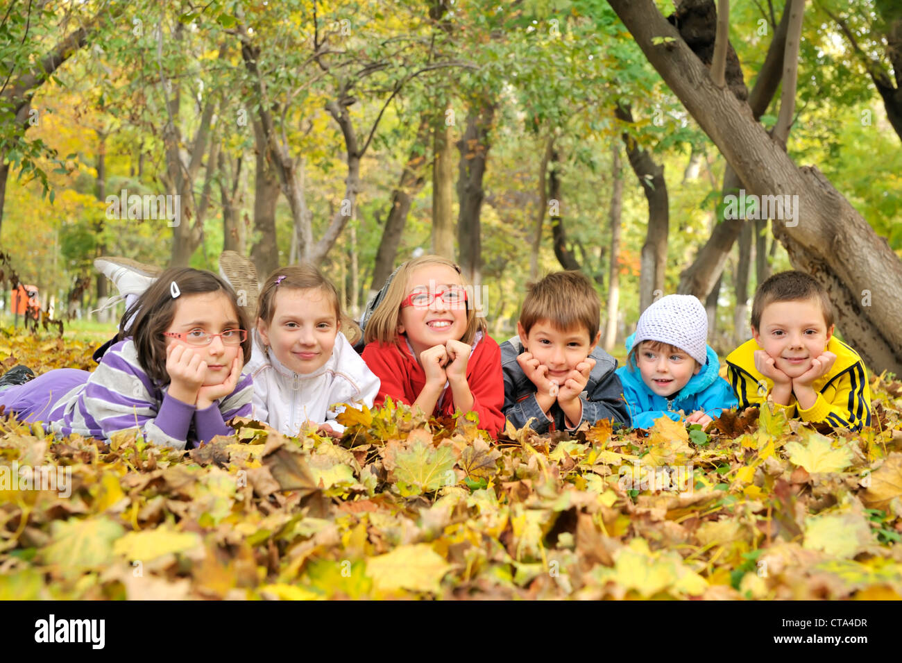 Kids giacente su foglie Foto Stock