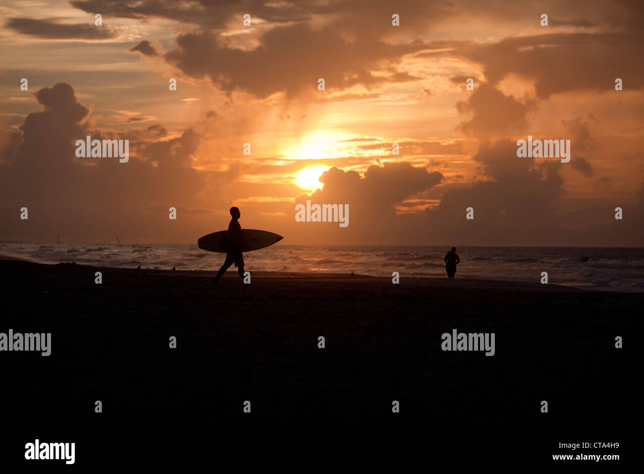 Un surfista stagliano contro il sole sul Surf City Beach , Topsail Island , North Carolina , USA Foto Stock