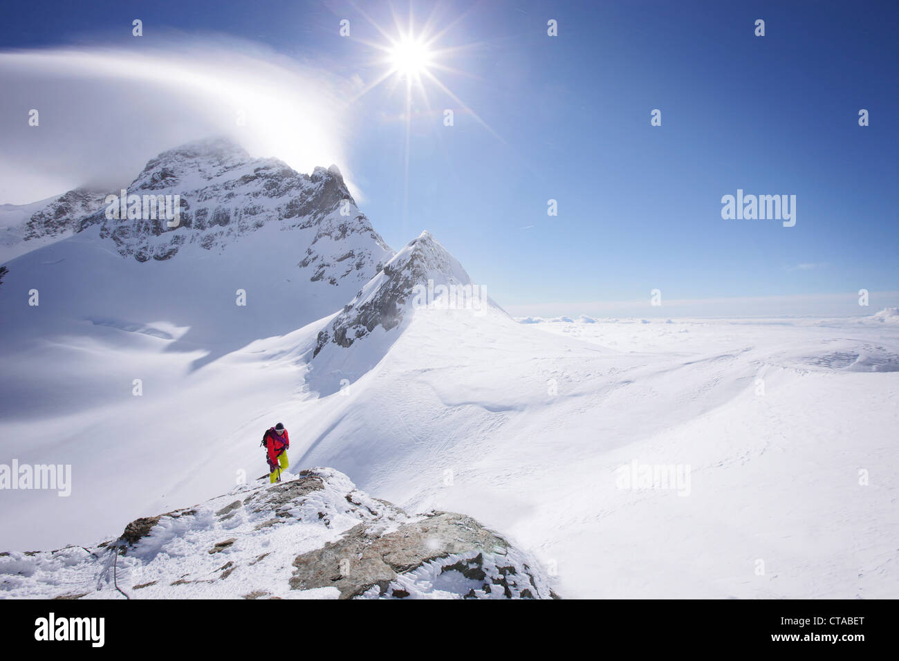 Alpinista al vertice del Jungfraujoch, Jungfrau in background, Grindelwald, Oberland bernese, Svizzera Foto Stock