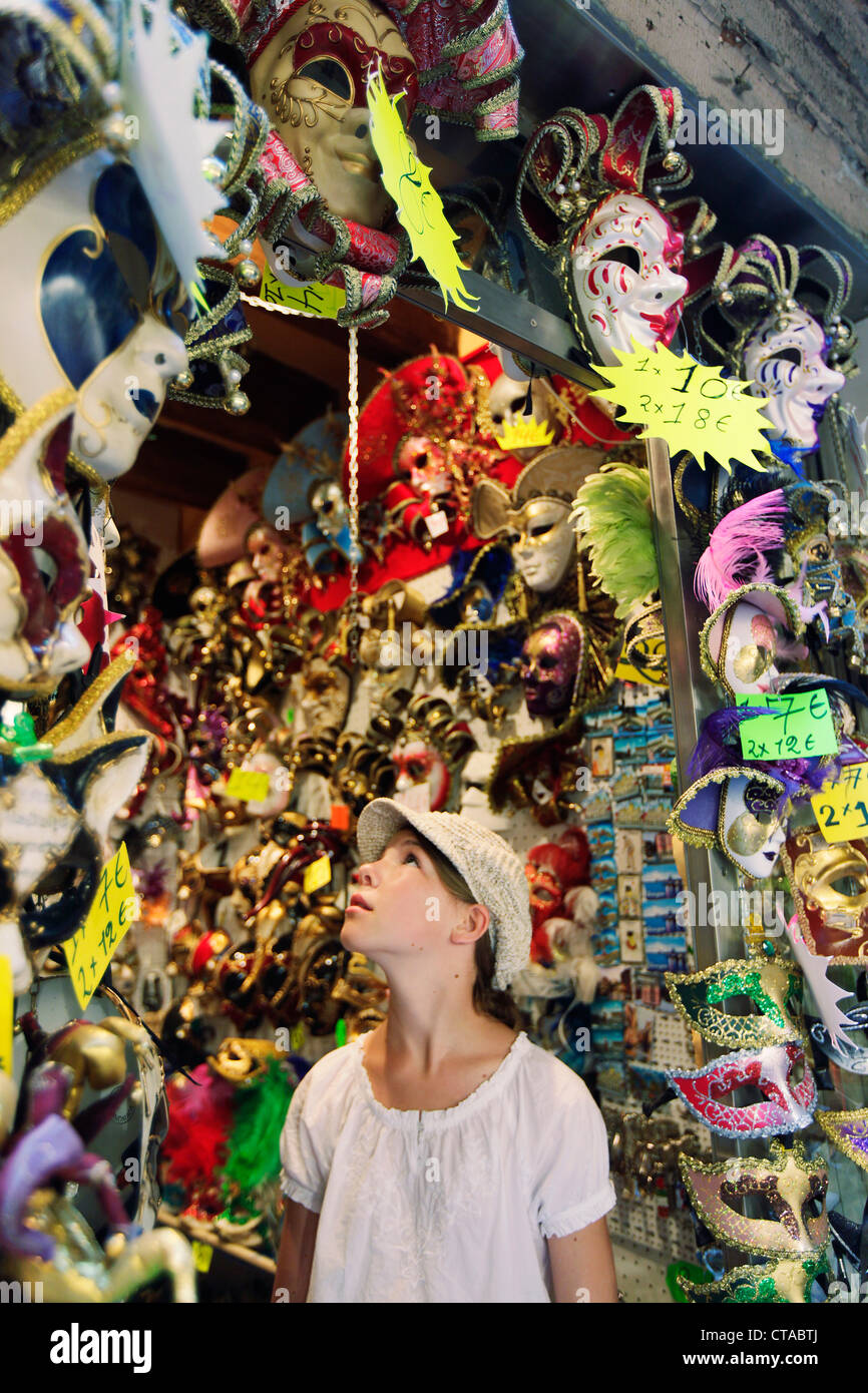 Ragazza, 12 anni, di fronte ad una maschera Veneziana shop, Venezia, Veneto, Italia Foto Stock