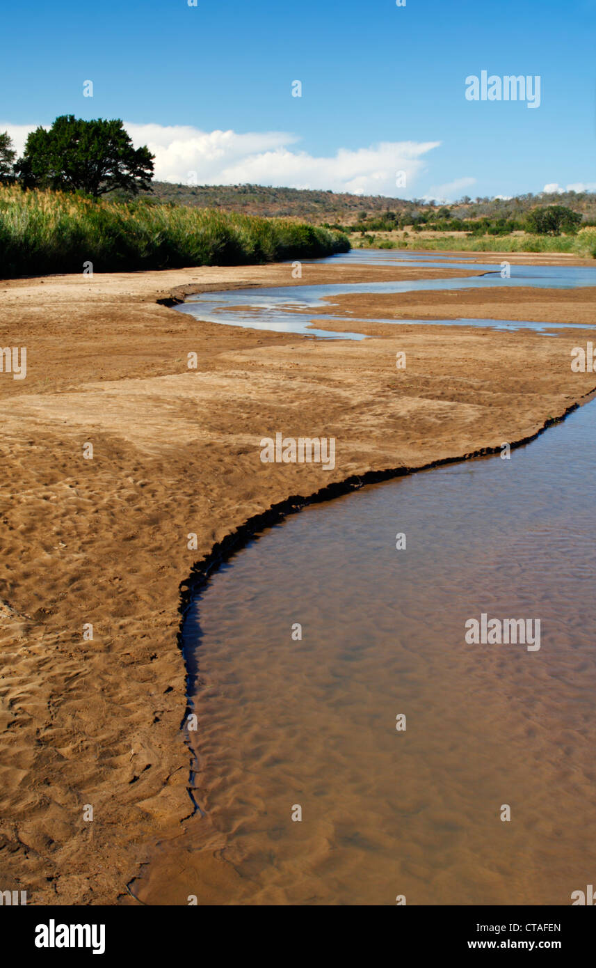 La Umfolozi nero fiume che scorre attraverso il Hluhluwe-Umfolozi Game Reserve in Kwazulu Natal, Sud Africa Foto Stock