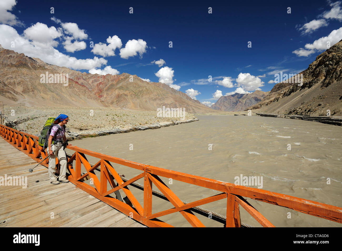 Donna di attraversamento del fiume Zanskar sul ponte di sospensione, Zangla, Zanskar gamma traversa, Zanskar Range, Zanskar, Ladakh, Jammu e Kas Foto Stock