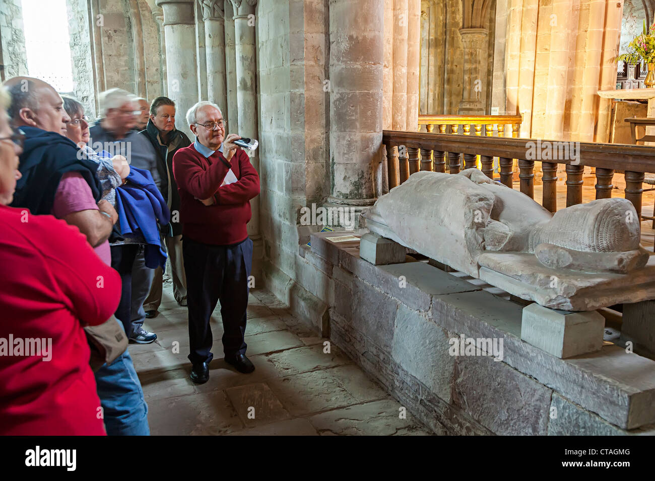 Guida con il gruppo turistico guardando sepoltura effigie in pietra sulla tomba, Abbey Dore, Herefordshire, England, Regno Unito Foto Stock