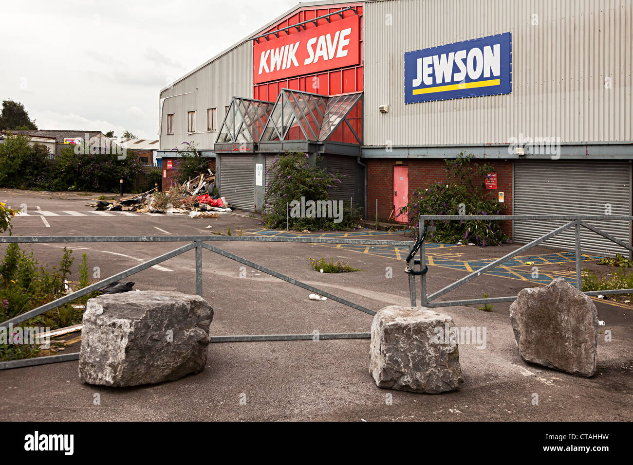 Chiuso in negozio con rocce posto come barriera al parcheggio, Cardiff Wales, Regno Unito Foto Stock