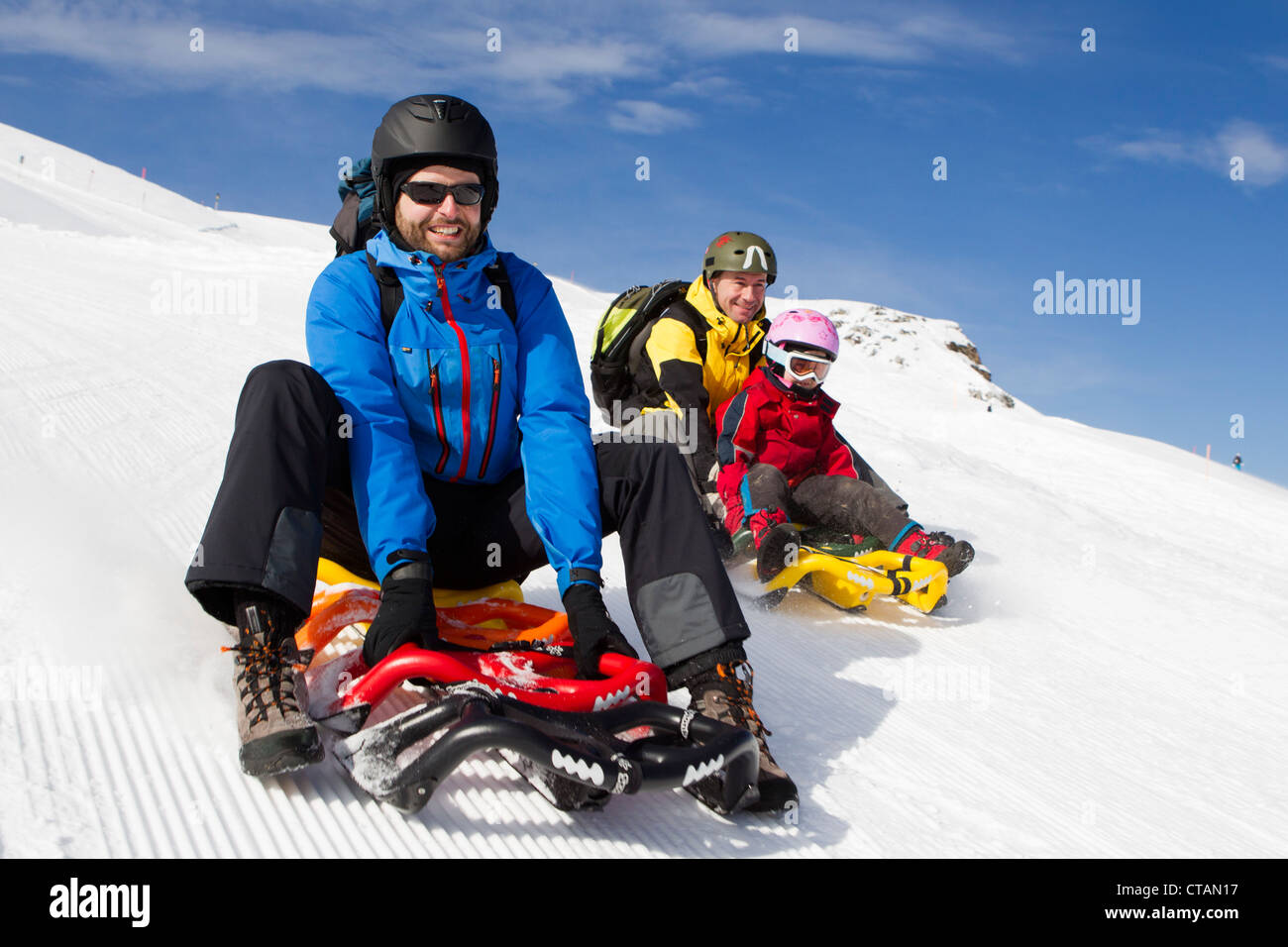 Una ragazza e due uomini slittino sulla pista di slittino a ski resort Stoos, Kanton Schwyz, Svizzera Foto Stock